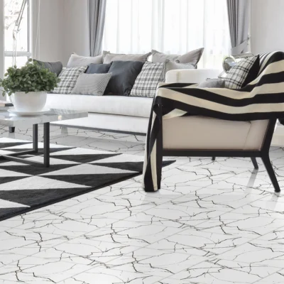 Sala iluminada con sofá blanco y cojines grises, piso de cerámica mármol Alvo, colección Ecos de Cerámicos Gala