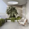 Exterior terraza adornado con plantas de ambiente y asientos de madera color beige, con un piso de cerámica mármol Grisel, colección Ecos de Cerámicos Gala